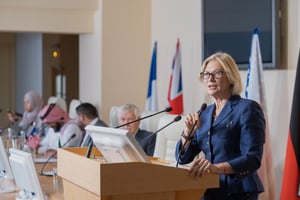 mature-female-speaker-elegant-suit-making-report